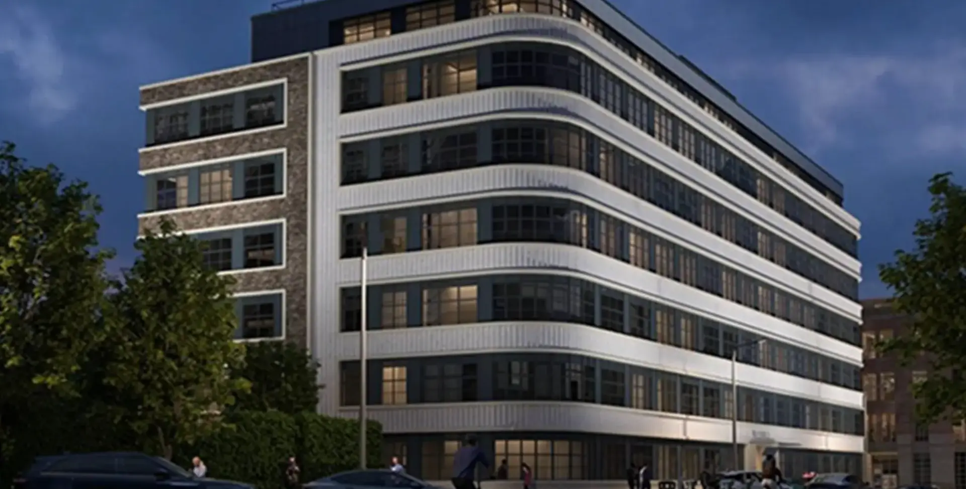 Willen House at 8 Bath Street, Islington, shown at dusk with its curved white banded façade and lit windows